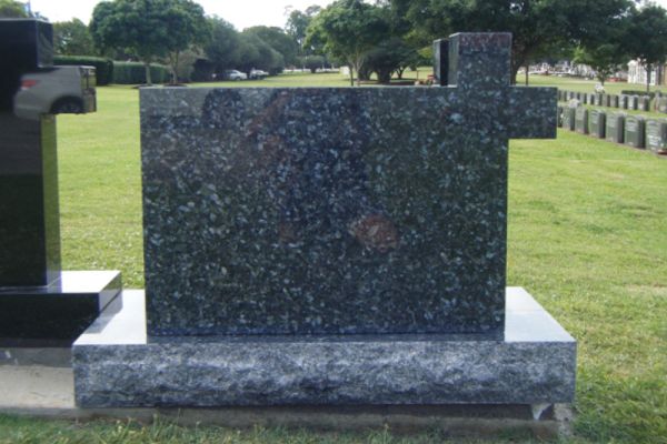Right hand monumental cross headstone and rustic base.