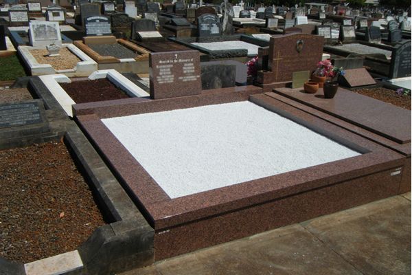 Granite veneer, kerbs and chips to floor with granite upright headstone.