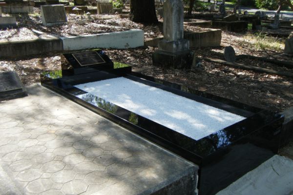Single Monument Grave - Australian Imperial Black desk, kerbs and front veneer, white chips on floor, bronze plaque fixed to the desk face.