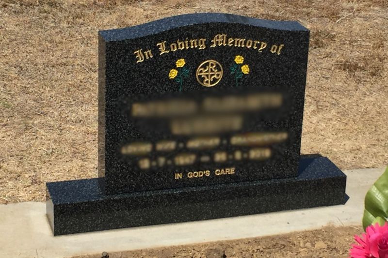 Coloured flowers and a religious symbol with a gold inscription finish this beautiful memorial stone.