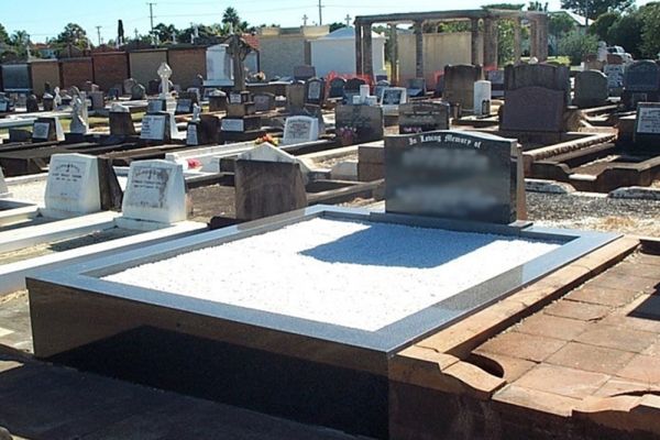 Kerbs and chips to floor, with granite upright headstone.