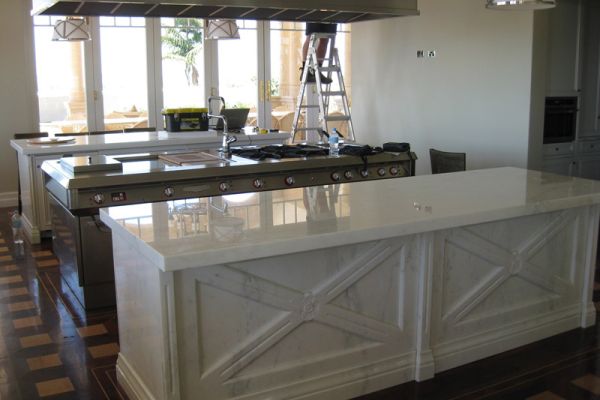 60mm thick marble island bench tops with a carved rosette and recessed front panel create a kitchen that dreams are made of.