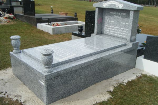 Australian Harcourt headstone, base, pediment, columns, kerbs, front veneer, side veners with white incised inscription and turned vases.